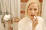 Woman putting on lipstick in bathroom mirror 1.jpg