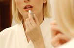 Woman putting on lipstick in bathroom mirror 2.jpg