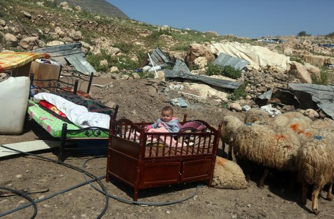 طفل فلسطيني في سريره في العراء بعد تدمير السلطات الاسرائيلية شرقي نابلس