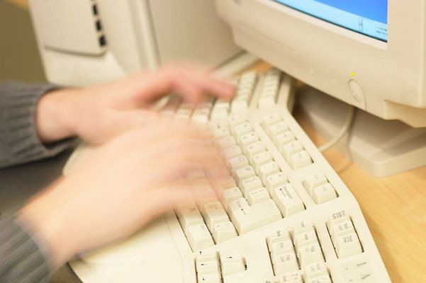Blur of Caucasian man typing on computer keyboard.jpg