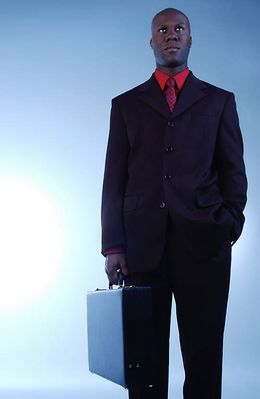 Businessman in black suit holding briefcase.jpg