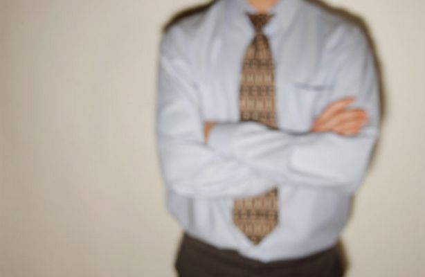 Businessman in tie leaning against wall 1.jpg