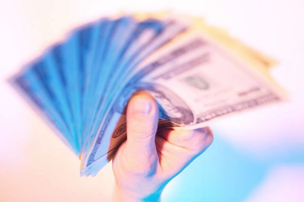 Caucasian man holding spread of American bills 1.jpg