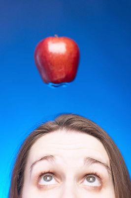 Caucasian woman face with apple hanging over her head against 1.jpg