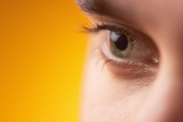 Close up of Caucasian man green eye against yellow background 3.jpg