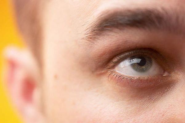 Close up of Caucasian man looking upwards against yellow backgro.jpg