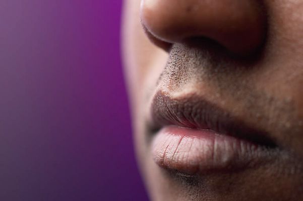Close up of South Asian man lips against purple background.jpg