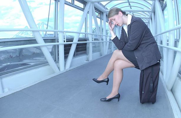 Frustrated business traveler sitting on her suitcase uid 1284398.jpg