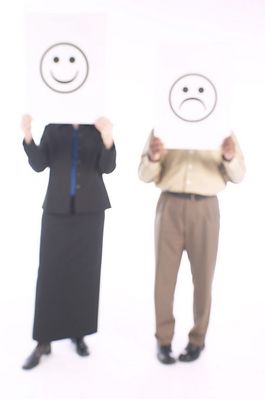Man and woman holding up happy and sad face signs.jpg