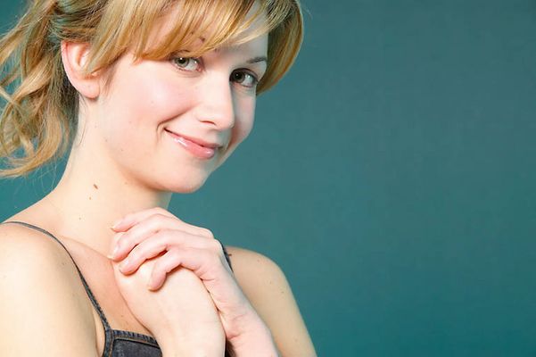 Smiling blonde with hands clasped together.jpg