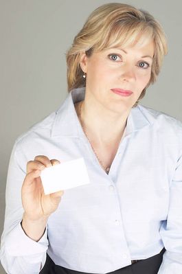 Smiling businesswoman holding out business card uid 1280860.jpg