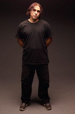 Standing man with long hair wearing black.jpg