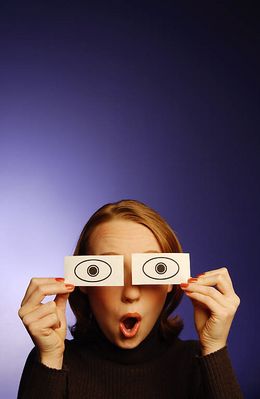 Surprised woman holding paper eyes to her face 3.jpg