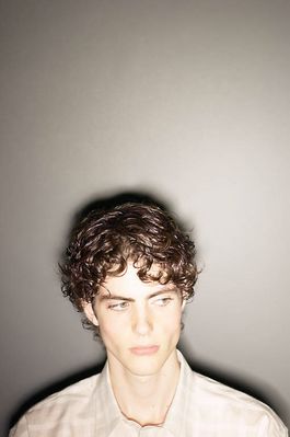 Teenaged boy against gray wall 2.jpg
