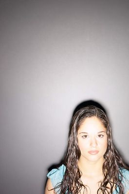 Teenaged girl standing against gray wall.jpg