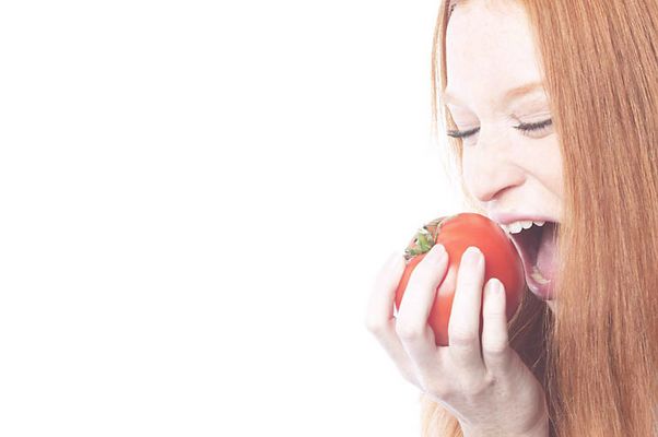 Woman biting tomato uid 1343059.jpg