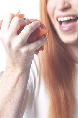 Woman eating tomato uid 1343069.jpg