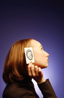 Woman holding paper ear to the side of her head 1.jpg