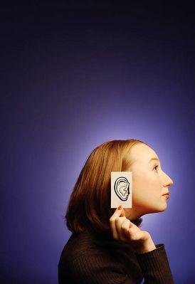 Woman holding paper ear to the side of her head 2.jpg