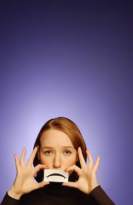 Woman holding paper frown to her face.jpg