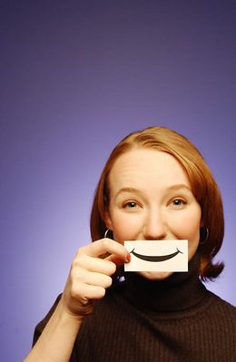 Woman holding paper smile to her face.jpg