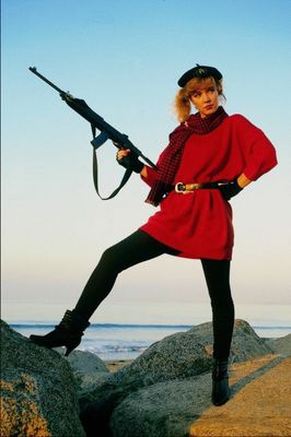 Woman in short red dress with assault rifle on bea.jpg