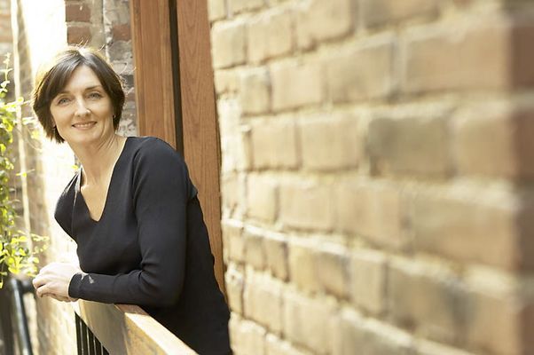 Woman leaning on balcony of brick building.jpg