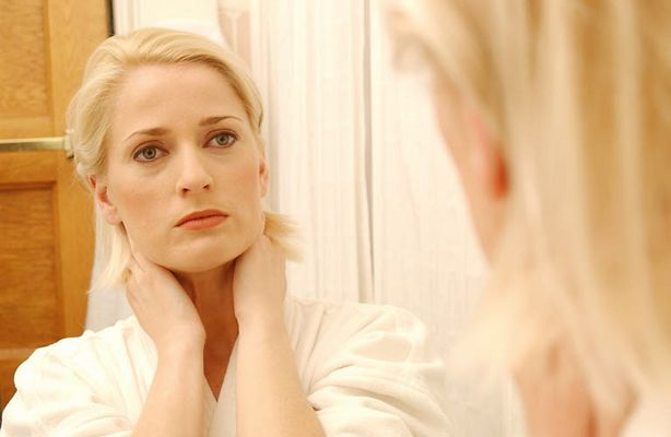 Woman looking at her face in bathroom mirror 3.jpg