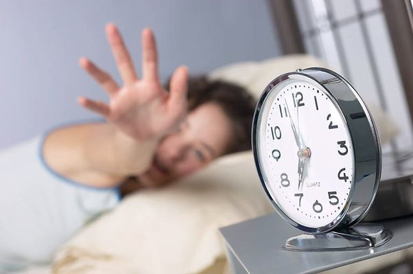 Woman reaching for alarm clock.jpg