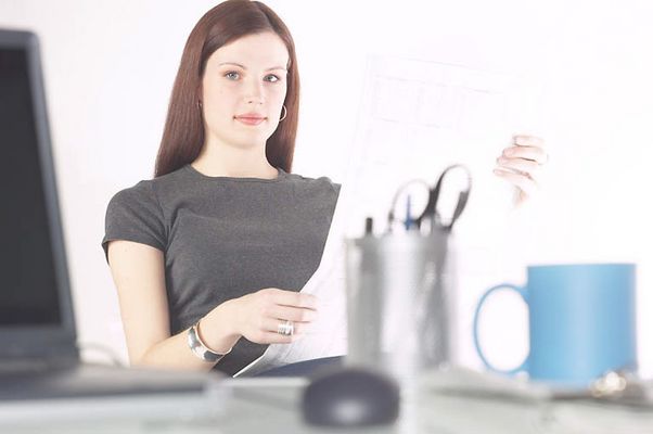 Woman reading newspaper at her desk 3.jpg
