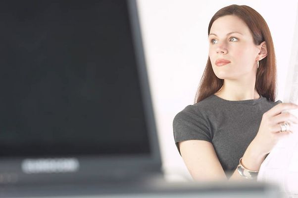 Woman reading newspaper at her desk 7.jpg