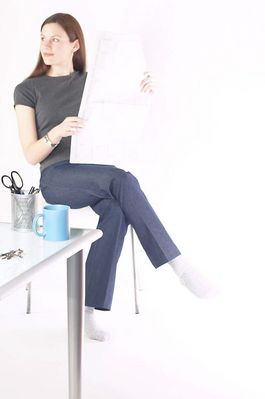 Woman sitting and reading newspaper at desk 1.jpg