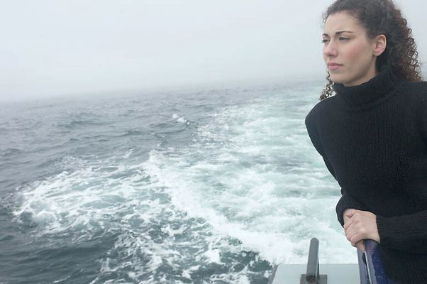 Woman standing on edge of boat uid 1283631.jpg