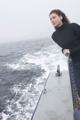 Woman standing on edge of boat uid 1283633.jpg