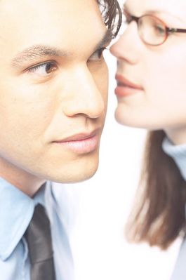 Woman whispering secret into man ear.jpg