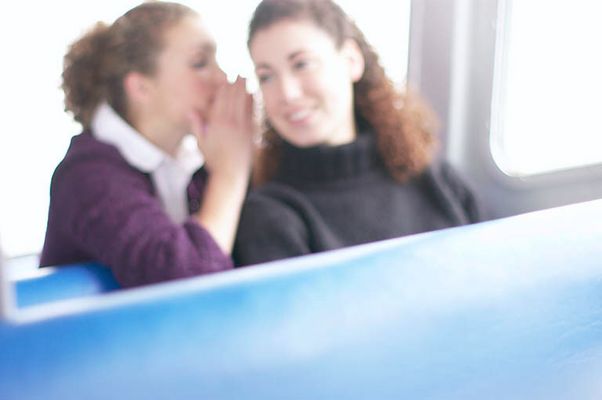 Woman whispering secret to her friend.jpg