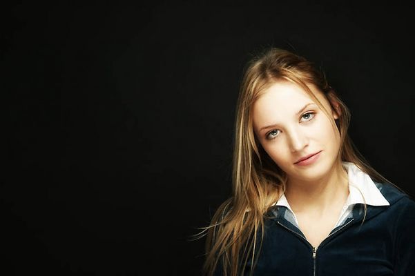 Young blonde woman with a black background.jpg