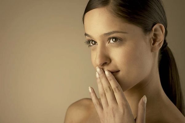 Young woman holding hand to mouth.jpg