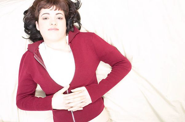 Young woman in red sweater lying in bed uid 1427244.jpg