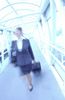 Businesswoman pulling suitcase through glass hallway.jpg