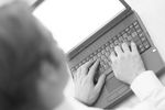 Caucasian business man typing on black laptop computer.jpg