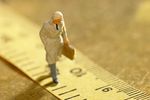 Model of businessman walking along ruler with briefcase.jpg