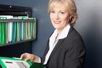 Smiling businesswoman reading file 1.jpg