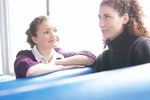 Two women sitting in blue vinyl seats uid 1283661.jpg
