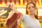 Woman gingerly holding up package of meat an 3.jpg