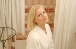 Woman in white bathrobe looking in bathroom mirror.jpg