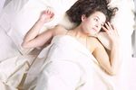 Woman lying in white bed sheets.jpg