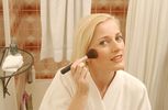 Woman putting on makeup in bathroom mirror 1.jpg