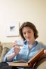 Woman reading book and drinking glass of water.jpg