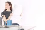 Woman reading newspaper at her desk 5.jpg